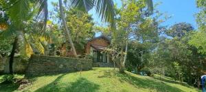 una casa con una pared de piedra en el patio en Spirit of Life Ayurveda and Yoga Resort, en Induruwa