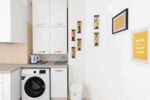 a kitchen with a washing machine and a wall with pictures at Casa cobalto vicinissima al centro by Turin House Collection in Turin