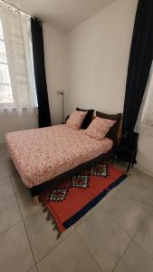 a bedroom with a bed with pillows and a rug at Le Coin des 3 Étoiles in Marseille