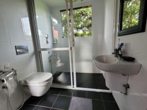 une salle de bain avec toilettes, lavabo et douche dans l'établissement Spirit of Life Ayurveda and Yoga Resort, à Induruwa