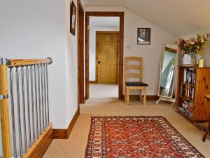 a hallway with a radiator and a door and a rug at Rathlin Coach House in Comrie +3 photos