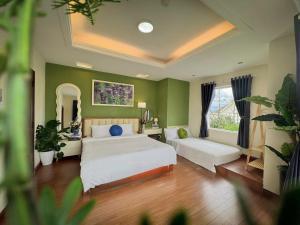 a bedroom with two beds and a large window at De Brume Villa in Da Lat