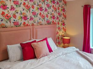 a bedroom with a bed with red and white pillows at Railway Cottage in Stanhope