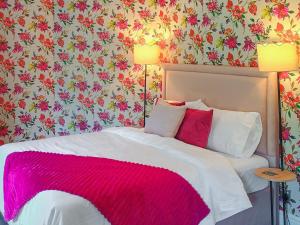 a bedroom with a bed with a pink blanket at Railway Cottage in Stanhope +7 photos