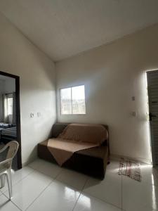 a bedroom with a bed in the corner of a room at Kitnets há 500m da Praia do Mutá in Porto Seguro