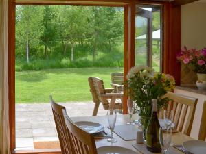 a table with a vase of flowers on top of it at Applebarrel Barn in Dunkeswell