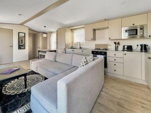 a living room with a couch and a kitchen at Rosie's Retreat in Morpeth