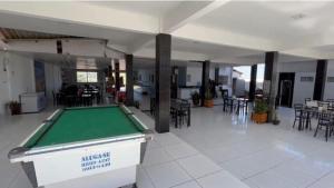 a pool table in a room with tables and chairs at Pousada e Restaurante Ponta do Mel in Areia Branca