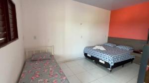 two beds in a room with red and white walls at Pousada e Restaurante Ponta do Mel in Areia Branca