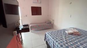 a bedroom with a bed and a tv in a room at Pousada e Restaurante Ponta do Mel in Areia Branca