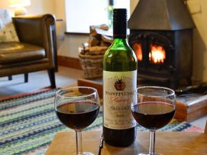 une bouteille de vin et deux verres sur une table dans l'établissement Cefn Canol, à Betws-y-coed