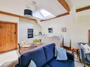 une cuisine avec un canapé bleu et une table en bois dans l'établissement Cefn Canol, à Betws-y-coed