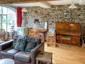 a living room with a couch and a piano at Brewhouse - Uk48743 in Llandybie
