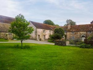 an old stone building with a tree in the yard at Brewhouse - Uk48743 in Llandybie