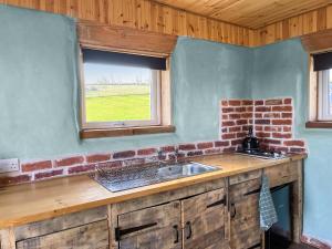 a kitchen with a sink and a window at Honeysuckle Bale Cabin - Uk49073 in Ballindalloch