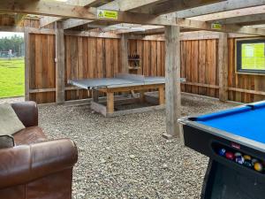 a pool table in a backyard with a ping pong table at Honeysuckle Bale Cabin - Uk49073 in Ballindalloch