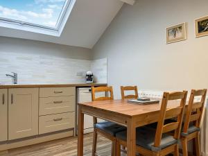 a kitchen with a table and chairs and a skylight at The Old Hayloft-Uk39431 in Dronfield