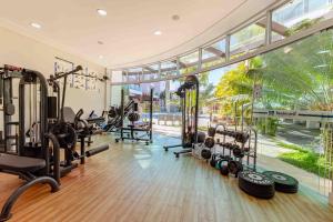 a gym with tread machines and a large window at Boulevard Bombinhas - Lindíssimo Apartamento em Condo com Piscina e Jacuzzi in Bombinhas