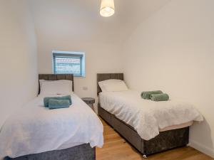 two beds in a room with white walls at Wheel House - Uk41247 in Hawsker