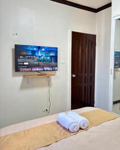 een slaapkamer met een bed en een flatscreen-tv aan de muur bij 2 Bedrooms Cozy Apartment Unit in Davao City +12 foto's