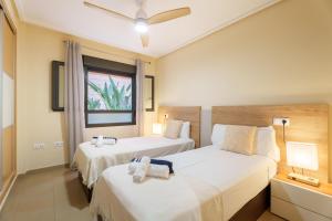 a bedroom with two beds and a window at Hogar Brisa de las Marinas acogedor apartamento con amplia terraza y acceso directo a las piscinas-Comfortable apartment with spacious terrace and direct pool access in Denia +40 photos