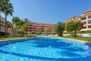a large swimming pool in front of a building at Hogar Brisa de las Marinas acogedor apartamento con amplia terraza y acceso directo a las piscinas-Comfortable apartment with spacious terrace and direct pool access in Denia