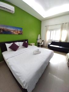 Un dormitorio con una gran cama blanca con una pared verde. en Happy Pool Villa near Jomtien Beach on Thepprasit Road, en Pattaya South 74 fotos más