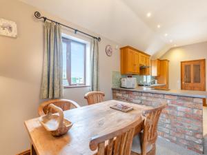une cuisine et une salle à manger avec une table et des chaises en bois dans l'établissement Ash Cottage - Uk45581, à Maltby le Marsh