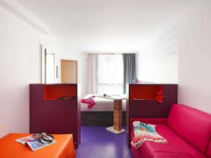 Una sala de estar con un sofá y un escritorio. en ibis Styles Montpellier Centre Comedie, en Montpellier
