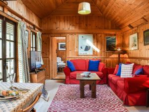 a living room with a red couch and a table at The Cottage At Dockens Water in Fritham