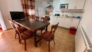 a kitchen with a dining room table and chairs at Casa azul in Nerpio
