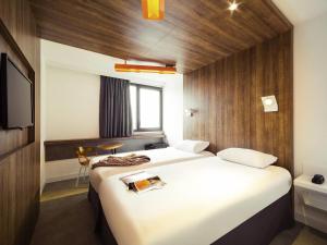 a hotel room with two beds and a television at ibis Styles Niort Poitou Charentes in Vouillé +72 photos