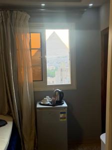 a small refrigerator in a room with a window at pYramids sun hOtel in Cairo