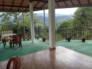 a screened in porch with a table and chairs on it at Mountain Top Guest in Bandarawela