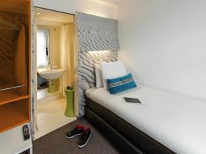een kleine slaapkamer met een bed, een wastafel en een spiegel bij ibis Styles Amsterdam Central Station in Amsterdam +38 foto's