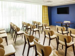 a room with chairs and a table and a tv at ibis Styles Birmingham Centre in Birmingham