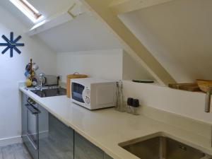 een keuken met een aanrecht met een magnetron bij Horsley Cottage in Rochester