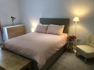 een slaapkamer met een groot bed en een stoel bij Horsley Cottage in Rochester