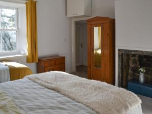 een slaapkamer met een bed en een open haard bij Horsley Cottage in Rochester +4 foto's