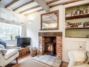 un soggiorno con camino e TV di September Cottage a Wenhaston