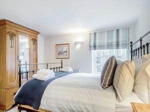 una camera da letto con un letto grande e una finestra di September Cottage a Wenhaston Altre 6 foto