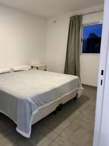 a bedroom with a white bed and a window at Departamentos Casa Pueblo in Villa Mercedes