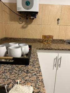 a counter with a bunch of white bowls on it at Departamentos Casa Pueblo in Villa Mercedes