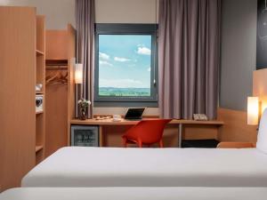a hotel room with a bed and a desk and a window at ibis Ankara Airport Hotel in Ankara