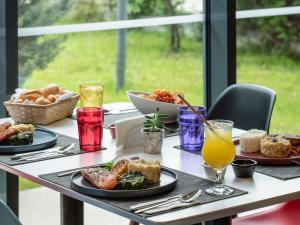 a table with plates of food and drinks on it at ibis Ankara Airport Hotel in Ankara