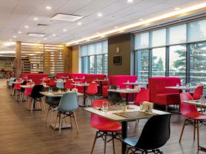 a restaurant with tables and chairs and red chairs at ibis Ankara Airport Hotel in Ankara