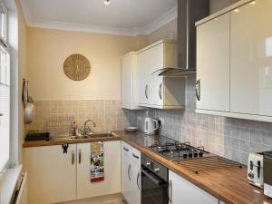 a kitchen with white cabinets and a clock on the wall at Inverness Haven in Inverness