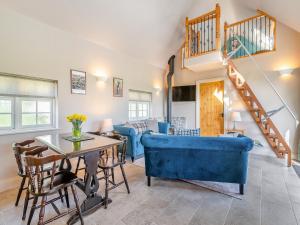 a living room with a blue couch and a table at Stone Cottage in Wedmore