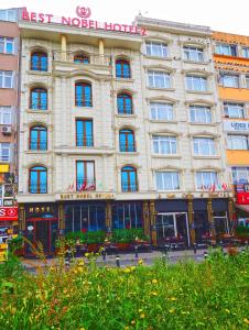 ein großes weißes Gebäude mit einem Schild darauf in der Unterkunft Grand Best Nobel Hotel İstanbul in Istanbul
