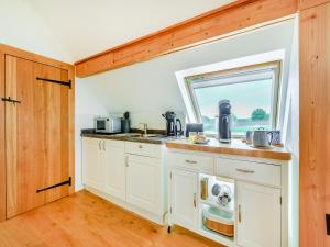 una cucina con un lavandino e una finestra di The Hay Loft - Uk46737 a Shapwick